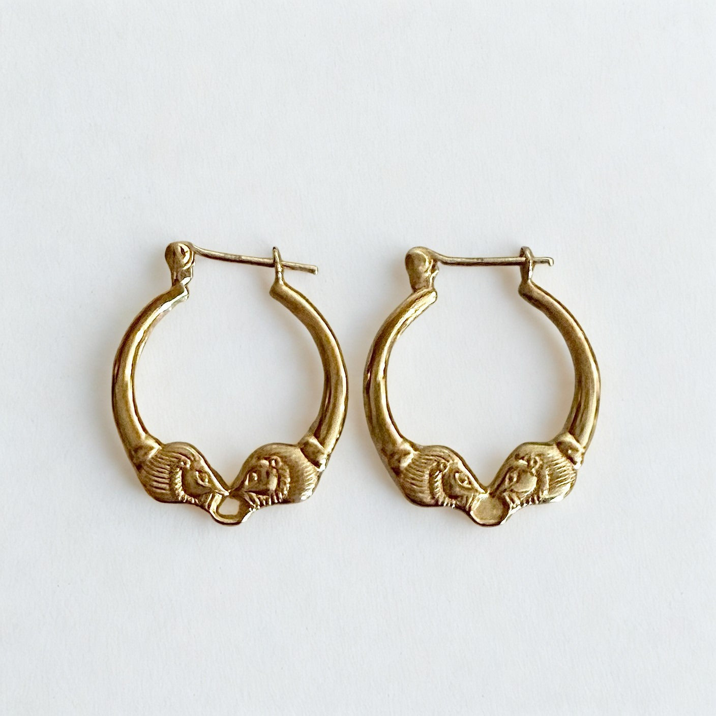 Pre-owned | Small 14k yellow gold ram head hoop earrings featuring a polished design and hinged posts.
