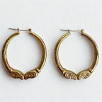 Pre-owned | 14k yellow gold ram head hoop earrings featuring a polished design and hinged posts.