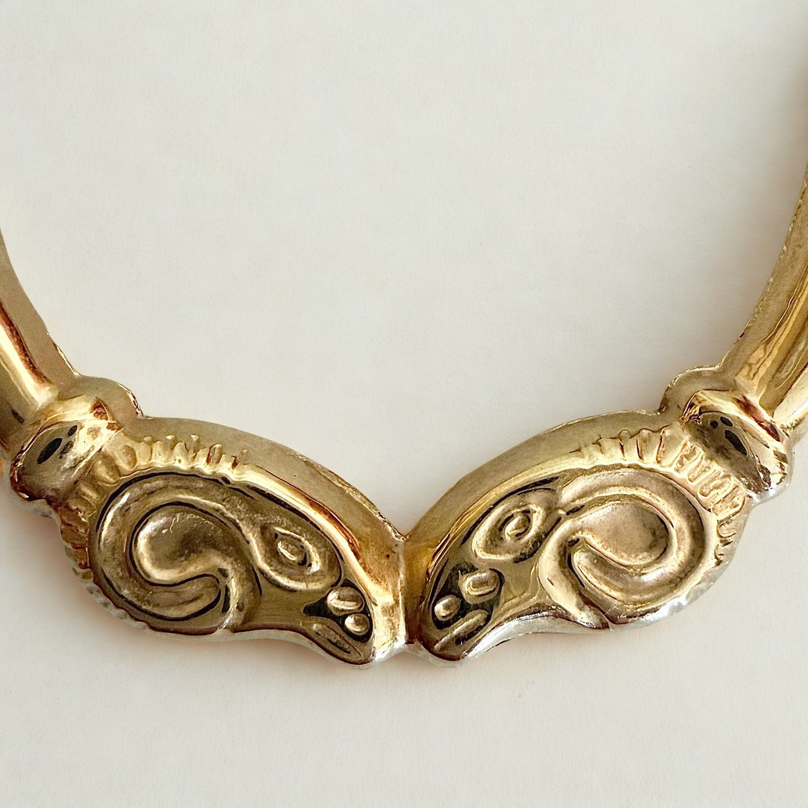 Pre-owned | 14k yellow gold ram head hoop earrings featuring a polished design and hinged posts.